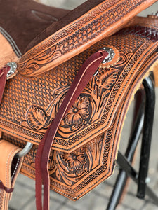 Classic western-style Ranchy Roper Saddle with 7/8 double rigging, floral stirrup covers, and Cheyenne roll cantle.