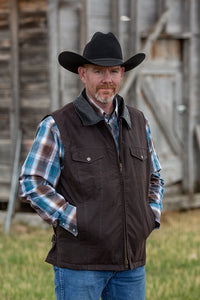 Oilskin Concealed Carry Vest made from water-resistant waxed canvas, featuring hidden holsters and adjustable straps.